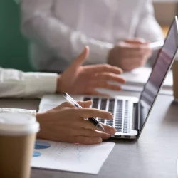 Businesswoman using laptop presenting project statistics report or market analysis at meeting, making offer or financial forecast, consulting clients, discussing work or negotiating, close up view